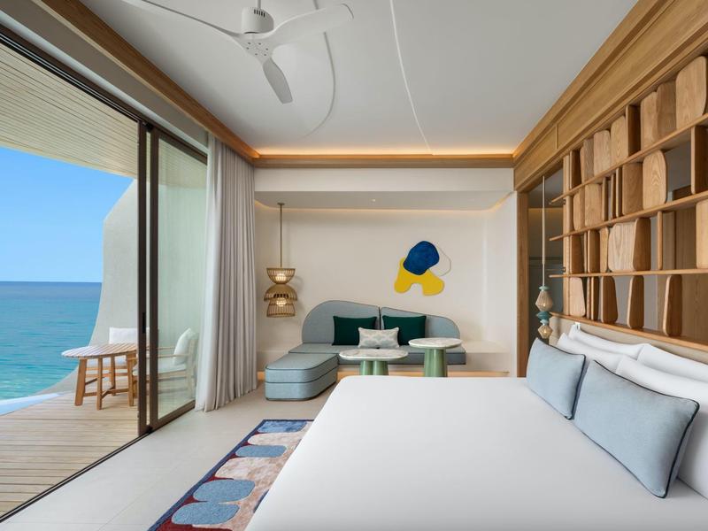 Habitación de hotel moderna con vista directa al mar y balcón.