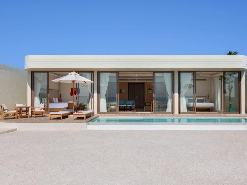 Casa moderna con gran piscina bajo un cielo azul claro