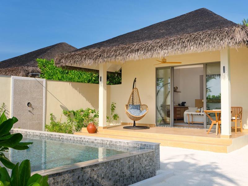 Villa bungalow moderne avec piscine, terrasse et fauteuil suspendu dans un cadre tropical