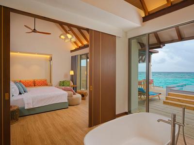 Luxuriöses Hotelzimmer mit offenem Bad und Meerblick, Holzboden und moderner Einrichtung.