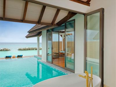 Moderner Hotelpool mit freistehender Badewanne und Meerblick unter Holzdeck