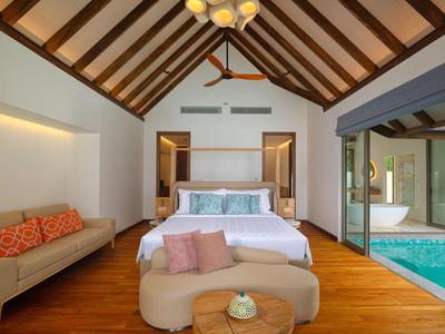 Modernes Hotelzimmer mit hohem Holzbalkendach, großem Bett und Zugang zu privatem Pool.