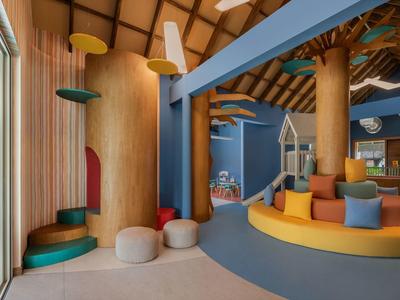 Interno adatto ai bambini con cuscini colorati, posti a sedere e decorazioni a forma di albero.