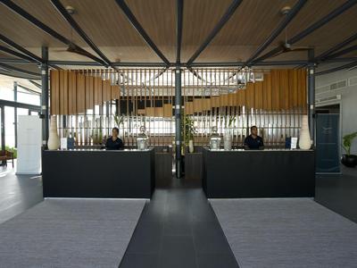 Moderner Hotellobby-Empfang mit zwei schwarzen Schaltern und großem Fenster im Hintergrund.