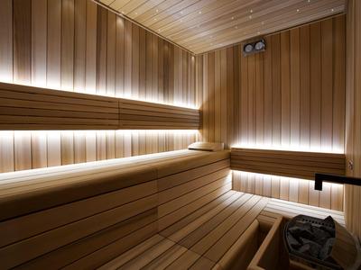 Helle, moderne Sauna mit Holzbänken und indirekter Beleuchtung für entspannte Urlaubsmomente.