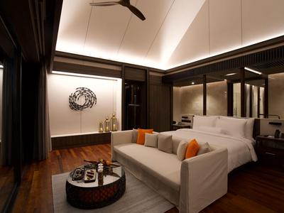 Modern eingerichtetes Hotelzimmer mit großem Bett, Sofa und indirekter Beleuchtung.