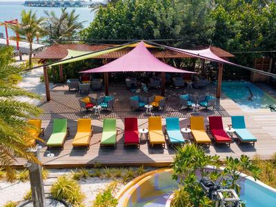 Colorful lounge chairs and sunshades in the pool area of a tropical hotel.