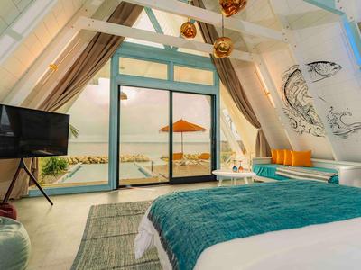 Cozy hotel room with slanted ceiling, large window, and terrace view with parasol.