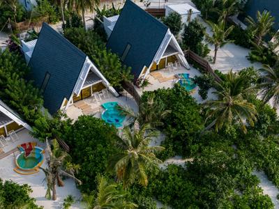 Two A-frame villas with blue roofs, each with a private pool, surrounded by palm trees and sand.