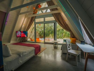 Modern hotel room with large windows and garden view.
