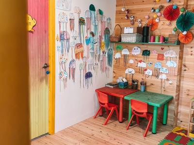 Colorful kids' area with small table set, play rug, and painted walls in a wooden room.