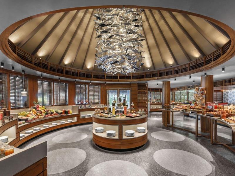 Elegantní bufetová část v hotelové restauraci s kulatým designem a stylovým osvětlením.