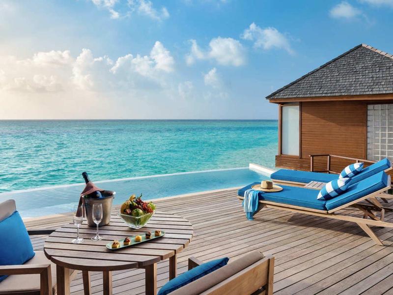 Terasa s lehátky a výhledem na oceán při západu slunce.