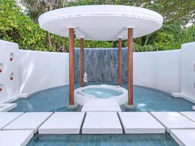 Baño exterior moderno con jacuzzi integrado y ducha en un entorno blanco elegante.