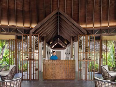 Accueil dans un hôtel tropical avec toit en bois et design ouvert.