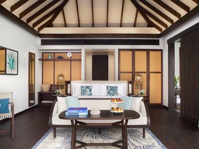 Elegancki salon z wysokim drewnianym sufitem, nowoczesnymi meblami i dużymi oknami.