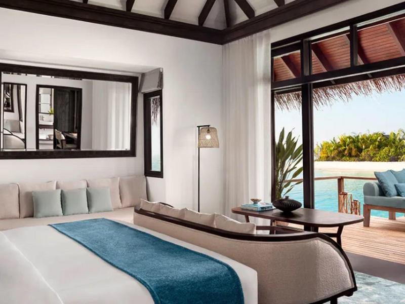 Nowoczesny pokój hotelowy z dużym łóżkiem i bezpośrednim dostępem do tarasu z widokiem na basen.