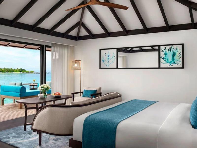 Luksusowy pokój hotelowy z widokiem na wodę, duże łóżka i nowoczesne wyposażenie.