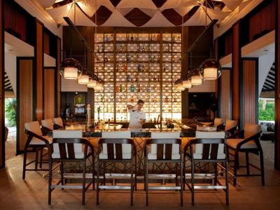 Stylish hotel bar area with wooden chairs and warm lighting creating a cozy ambiance.