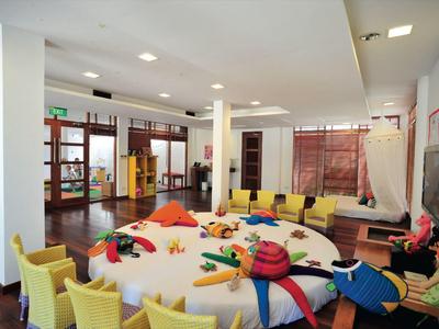 Ampia area con poltrone gialle attorno a un tavolo rotondo con cuscini colorati