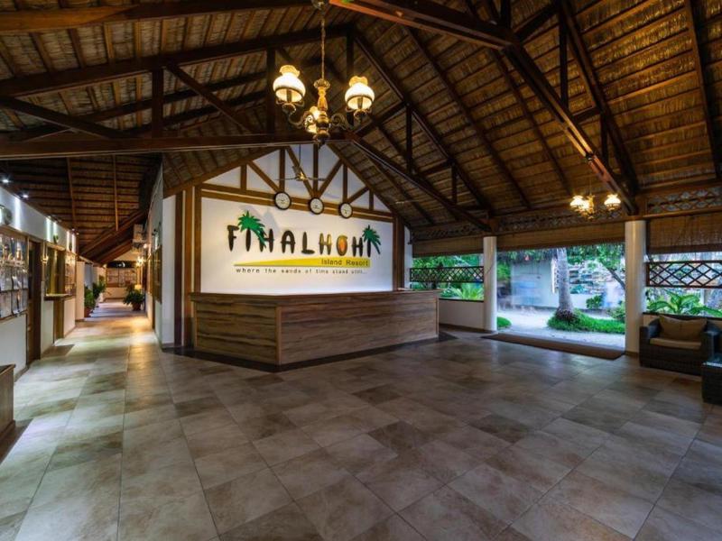 Velká vstupní hala s dřevěnou střechou, recepcí a sedacími prostory v hotelu.