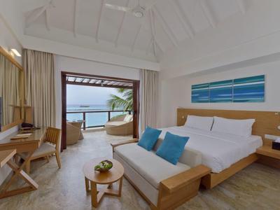 Modern eingerichtetes Hotelzimmer mit Doppelbett, Balkon und Blick auf das Meer.