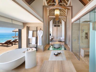 Luksusowa łazienka z wolnostojącą wanną, widokiem na morze i otwartym dostępem do tarasu.