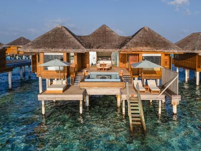 Bungalow sur pilotis avec piscine au-dessus d'eau claire tropicale