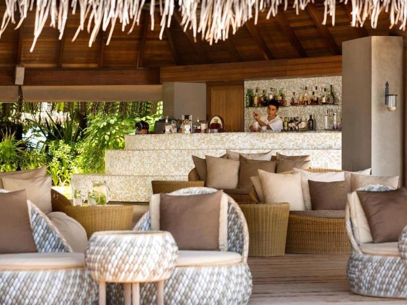 Espace lounge confortable avec fauteuils moelleux et bar dans un cadre ouvert et naturel.