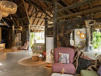 Gemütliche Hotellobby mit rustikaler Holzkonstruktion, weichen Sesseln und warmem Licht.