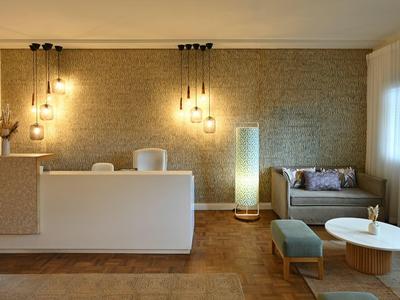 Helles, modernes Wohnzimmer mit weißem Sofa, minimalistischer Lampe und hellem Holzboden.