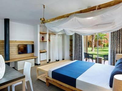 Chambre d'hôtel moderne avec lit à baldaquin et vue sur le jardin