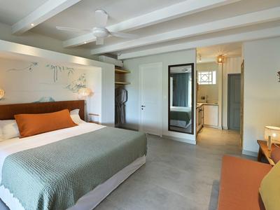 Modernes Hotelzimmer mit großem Bett, Deckenventilator und gemütlicher Einrichtung.