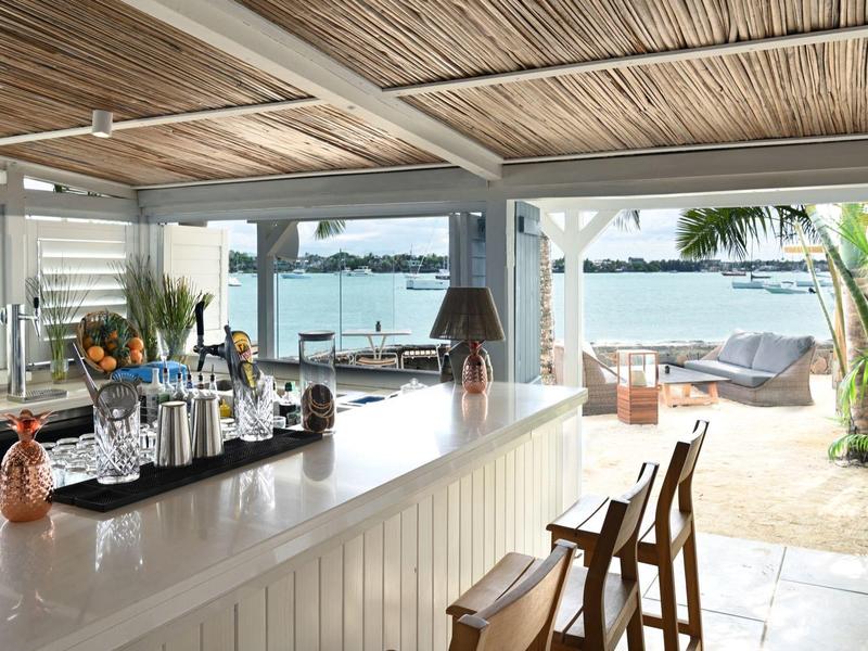 Moderner Barbereich mit Blick auf Wasser und Lounge-Bereich im Freien