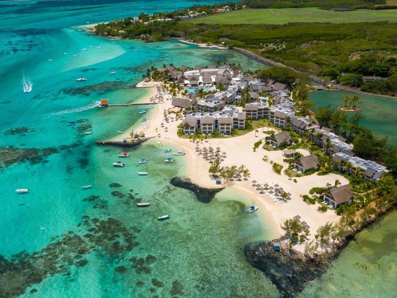 Luftaufnahme einer tropischen Insel mit weißen Sandstränden, türkisfarbenem Wasser und grüner Vegetation.