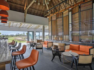 Área de salón moderna con sillas naranjas y una gran ventana panorámica.
