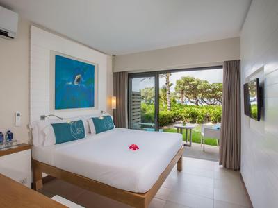 Bright hotel room with double bed and garden view.