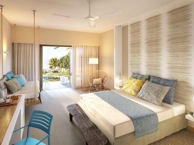 Modernes Hotelzimmer mit Doppelbett, Sitzecke und Zugang zu einer Terrasse mit Blick ins Grüne.