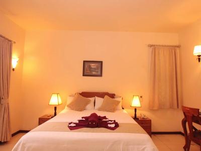 Gemütliches Hotelzimmer mit Doppelbett, Nachttischen und warmem Licht.