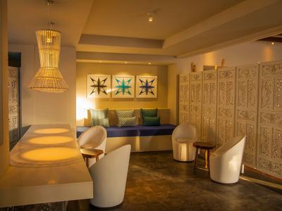 Przytulny salon z wygodnymi fotelami, dekoracyjnymi obrazami na ścianie i ciepłym światłem.