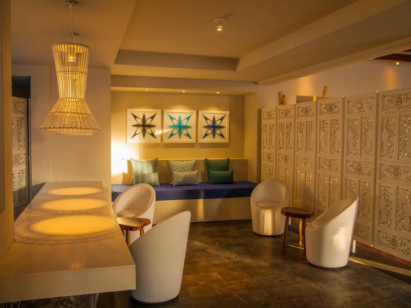 Przytulny salon z wygodnymi fotelami, dekoracyjnymi obrazami na ścianie i ciepłym światłem.