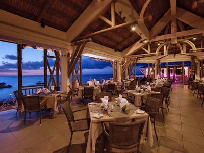 Ristorante sul mare con area coperta e vista sul tramonto.