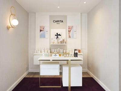 Eenvoudige spa-weergave met witte producten op een goud-witte tafel tegen een minimalistische muur.