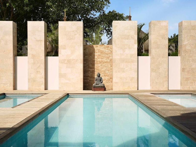 Modern zwembad met heldere wateroppervlakken en decoratieve pilaar buiten.