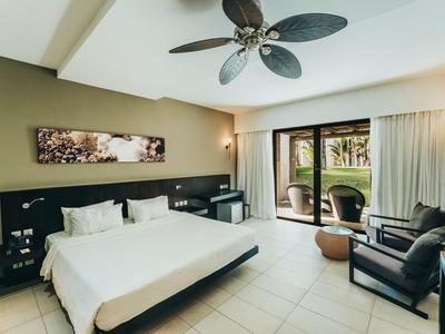 Helles Hotelzimmer mit Doppelbett, Balkonzugang und moderner Einrichtung.