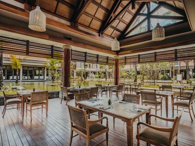 Helles Restaurant mit Holzdecke, Holzmöbeln und großem Fensterblick ins Grüne.
