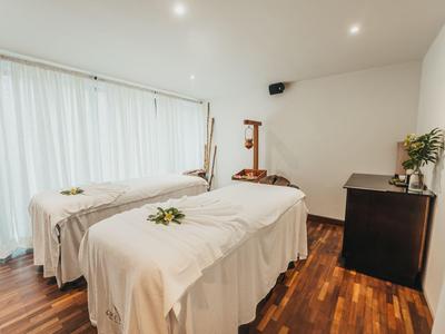 Helles, modernes Massagezimmer mit zwei Liegen und Holzboden in einem Wellnesshotel.