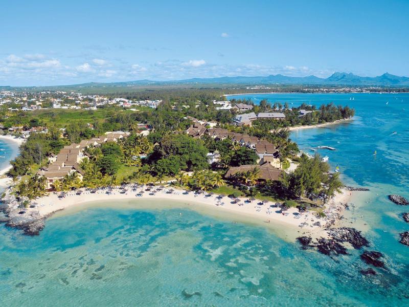 Aerial view of a tropical coastline with sandy beach and clear blue water.