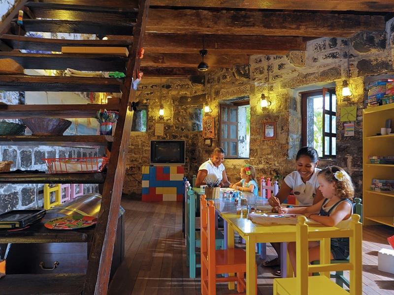 Cozy restaurant with rustic stone walls, wooden beams, and colorful wooden furniture