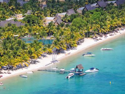 Pláž s palmami, loděmi a hotelem u tyrkysového moře